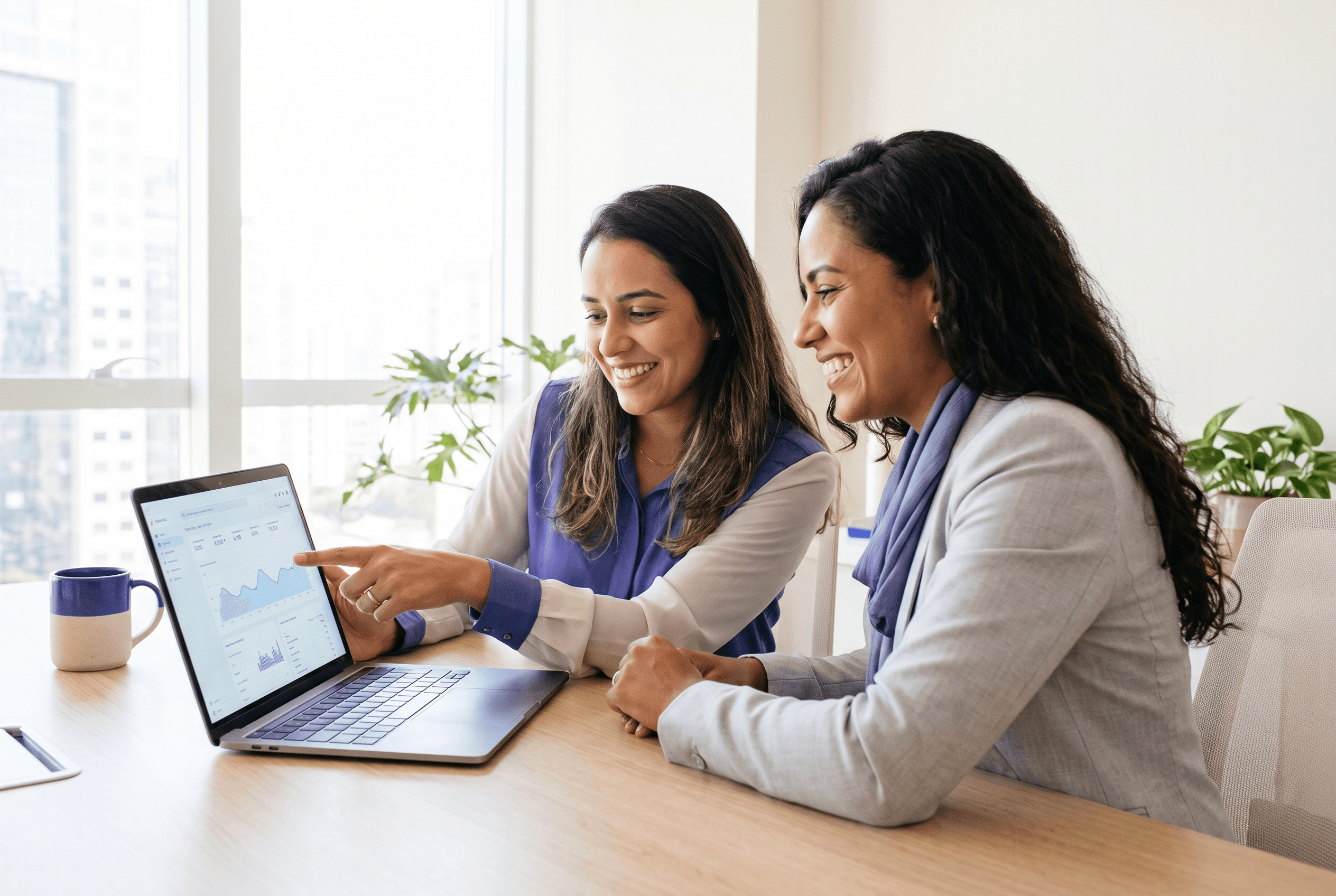 Especialista da operação analisando resultados ao lado da cliente, apontando o painel no notebook